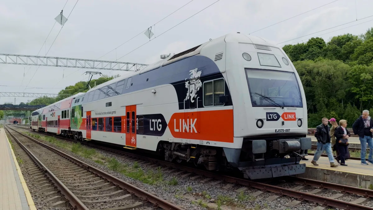 白とオレンジの2階建ての電車がホームに停まっている